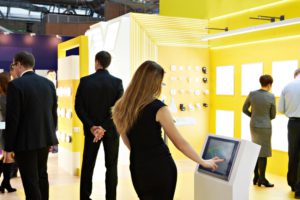 Women interacting with stand at exhibition