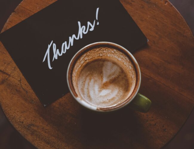A cup of coffee with a note that says Thank You