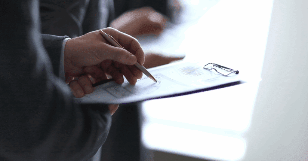 Close-up of an event organiser using a clipboard to track visitor data, illustrating the traditional "guesswork" that Exposure Analytics replaces with real-time Experience Intelligence.