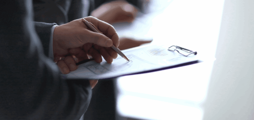 Close-up of an event organiser using a clipboard to track visitor data, illustrating the traditional "guesswork" that Exposure Analytics replaces with real-time Experience Intelligence.